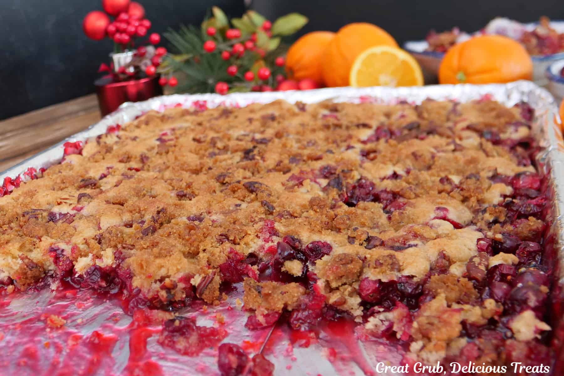A sheet pan with cranberry orange cobbler on it with some cobbler removed from the pan and served up.