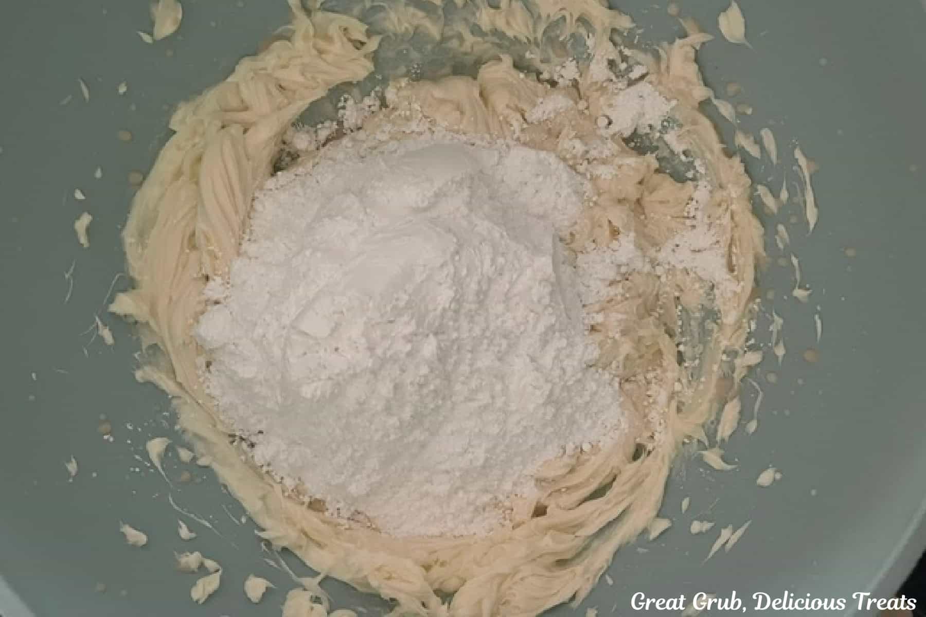 Buttercream frosting batter with powdered sugar added before being mixed together.