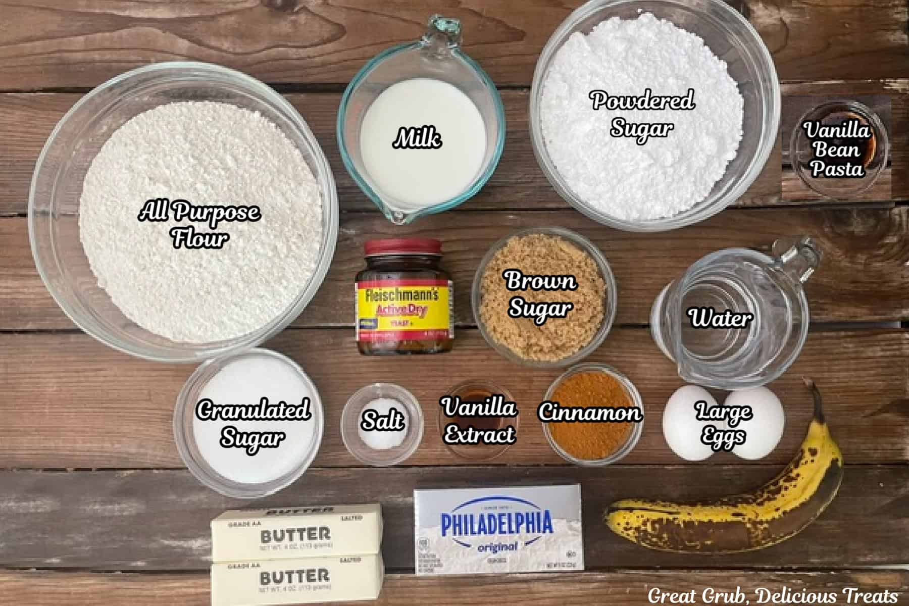 A rustic wood surface with all the ingredients placed on it to make homemade banana cinnamon rolls.