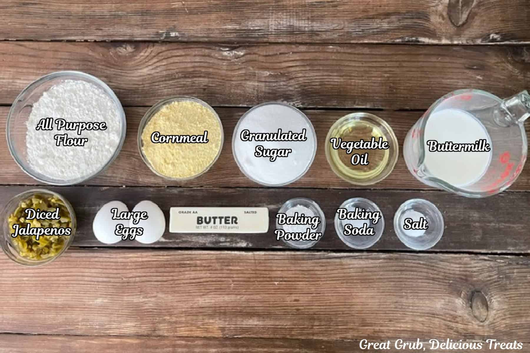 A rustic wood surface with all the ingredients placed on it to make jalapeno cornbread.