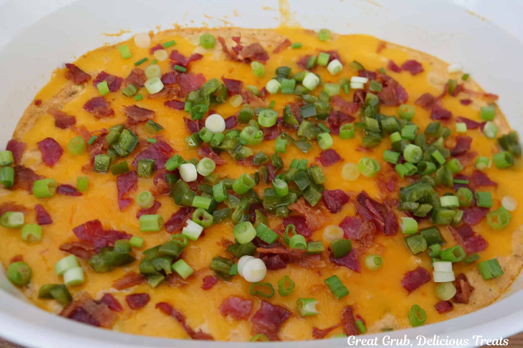Baked jalapeno popper dip in a white baking dish.