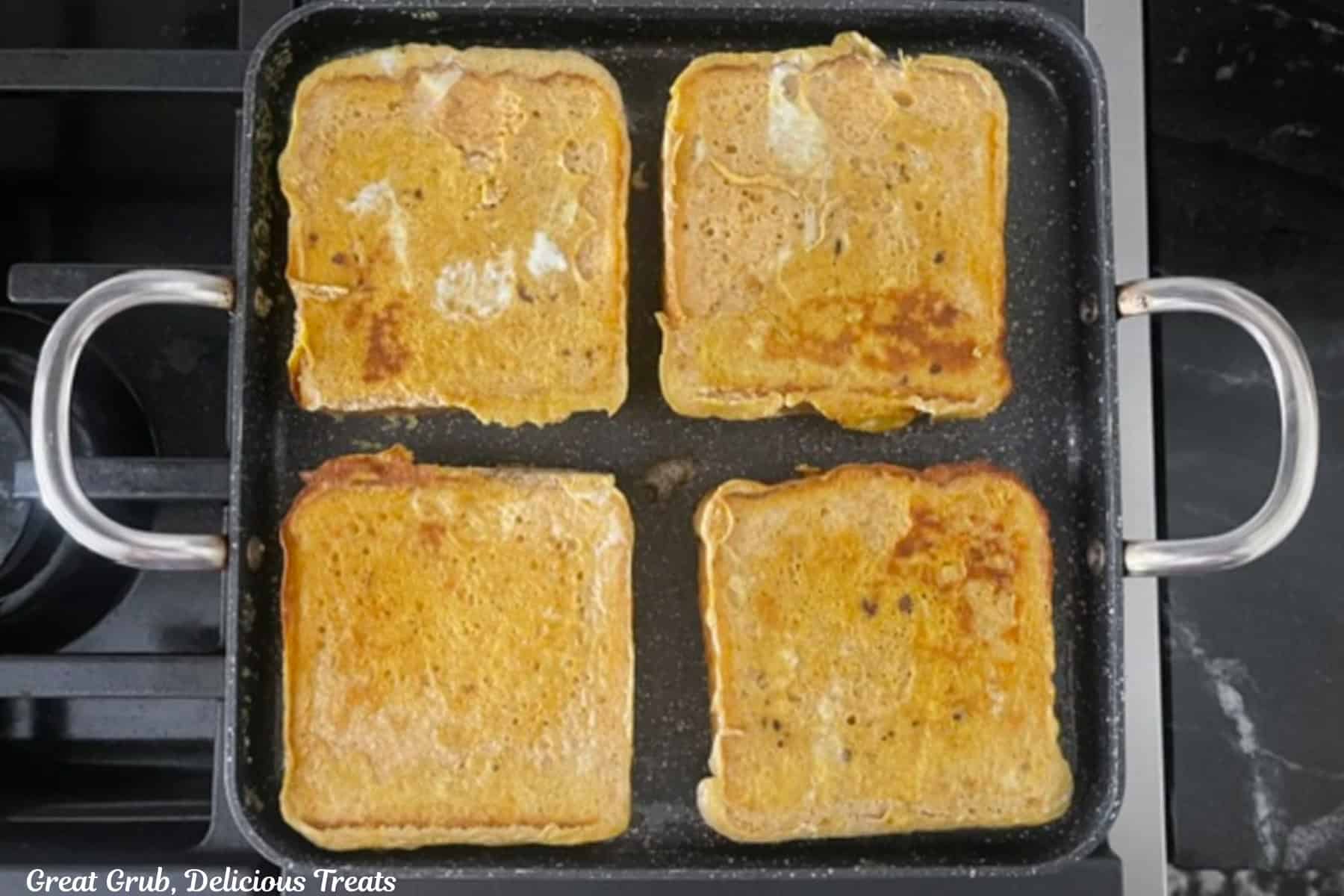 A square shallow frying pan with four slices of pumpkin spice French toast cooking.