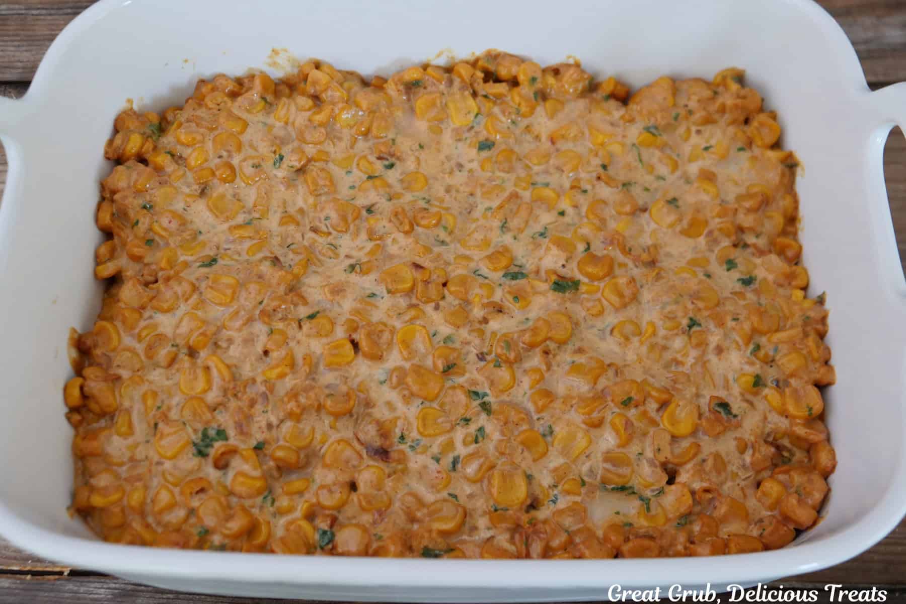 A white 7 by 11 baking dish with baked street corn dip in it.